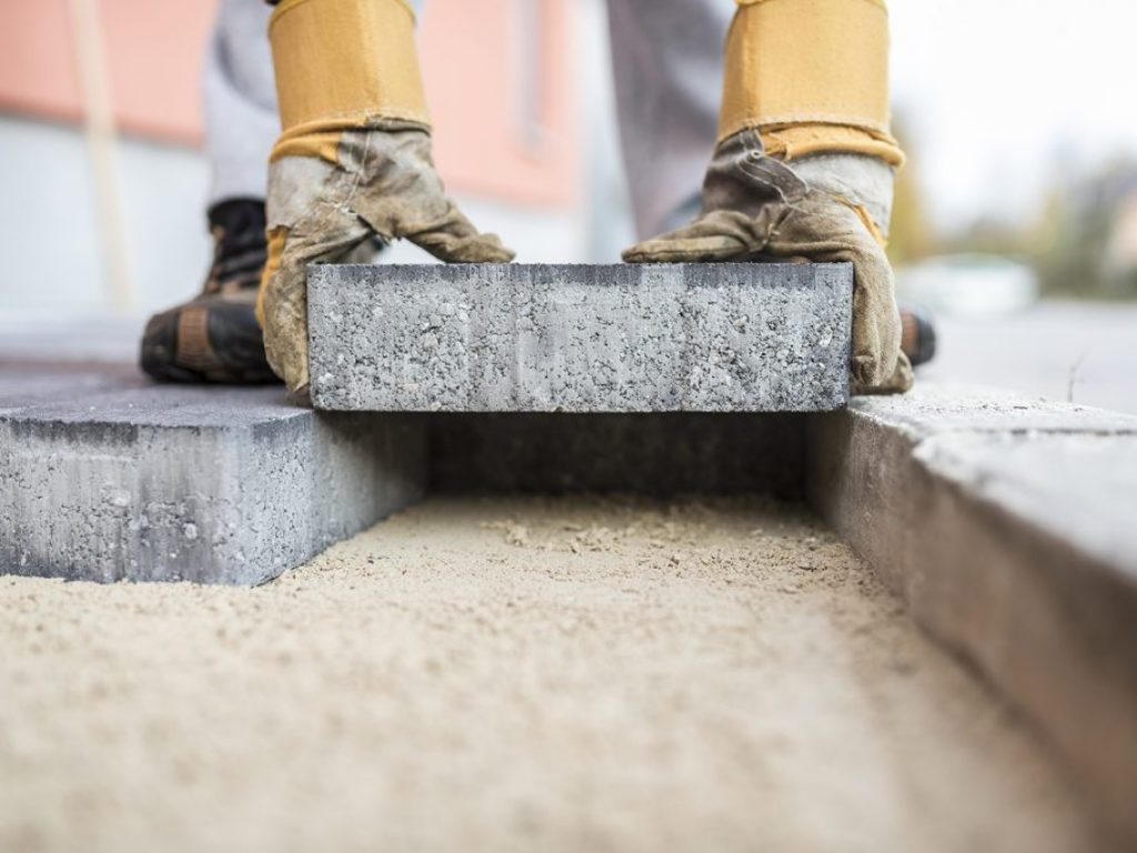 Builder laying outdoor paving slabs